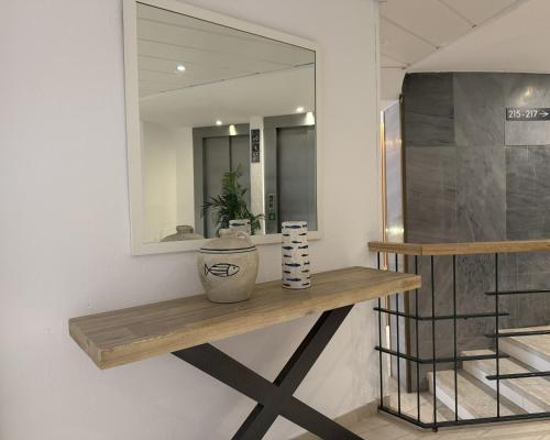 a wooden shelf on a wall with a mirror at Hotel Rosamar Maxim 4*- Adults Only in Lloret de Mar