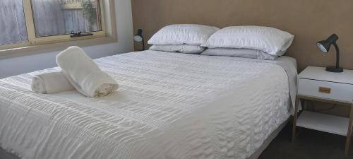 a white bed with two pillows on top of it at Margarets Lane in Warrnambool