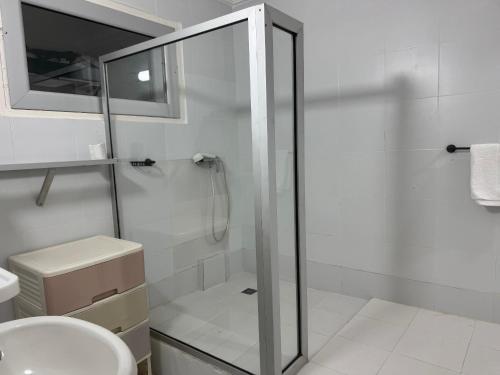a bathroom with a shower and a toilet and a sink at Maison Mimosa in Grand-Bassam