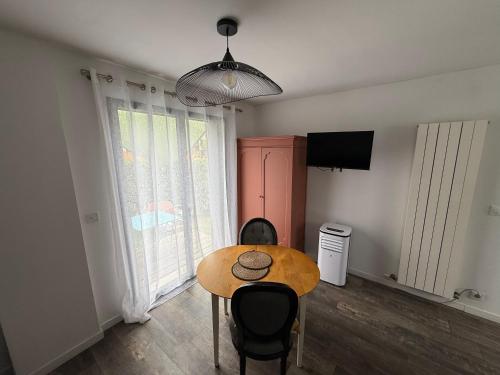 a room with a table and chairs and a television at L'Orée du Golf, studio 2 in Mont-Saint-Aignan