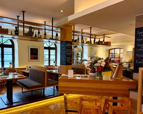 a dining room with tables and chairs and a restaurant at Hotel Angerbräu in Murnau am Staffelsee