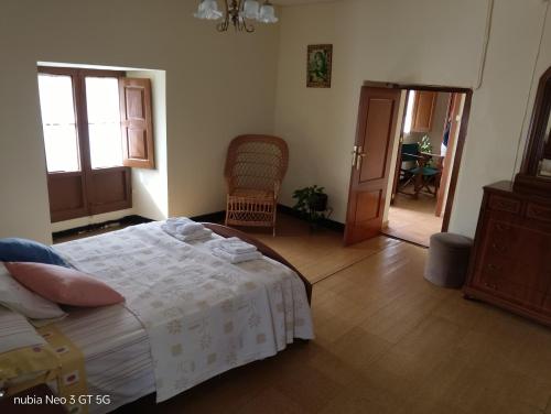 a bedroom with a bed and a hallway with a chair at La Chungita in Villanueva de Arosa
