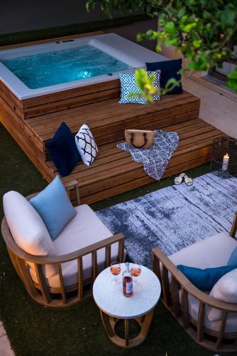 a patio with two chairs and a swimming pool at Urban Living Homes, with Jaccuzi in Agios Onoufrios