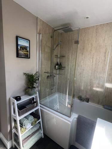 a bathroom with a tub and a shower with a glass door at The Ferry Loft Montrose in Montrose