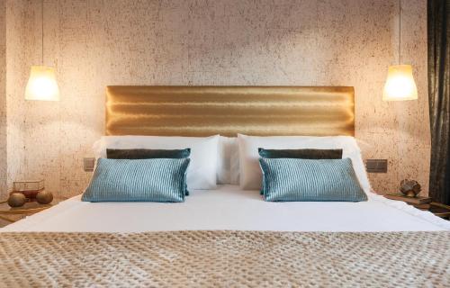 a bedroom with a bed with two blue pillows at Villa Birdie Boutique - Adults Only in Donostia-San Sebastián