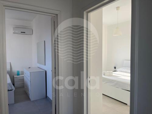 a glass door leading to a bedroom with a bed at La Torre - Piano Primo By Cala Salento in Torre Lapillo