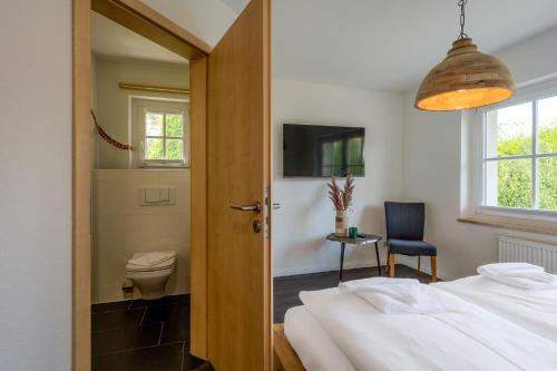 a bedroom with a bed and a toilet and a window at Seemannshus in Born
