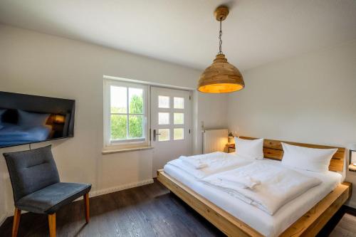 a bedroom with a large bed and a chair at Seemannshus in Born