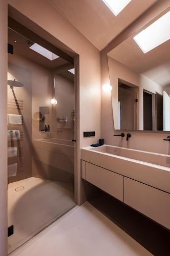 a bathroom with a tub and a sink and a mirror at Hotel Weingut Stroblhof in Appiano sulla Strada del Vino
