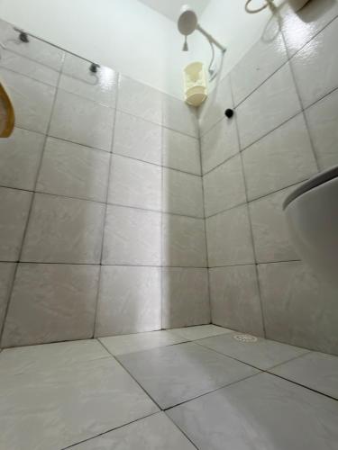 a bathroom with a shower with a toilet and a light at Pousada O Leão in Piaçabuçu