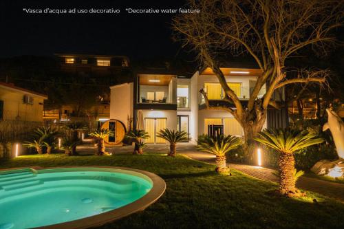 a swimming pool in front of a house at night at Luxury B&B La Riserva Dannunziana in Pescara