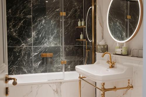 a bathroom with a sink and a shower at Castle Hotel Windsor in Windsor