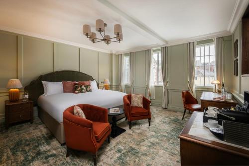 a hotel room with a bed and a desk and chairs at Castle Hotel Windsor in Windsor