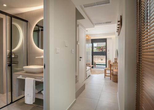 a bathroom with a sink and a mirror at Villas THALLO in Paradisos