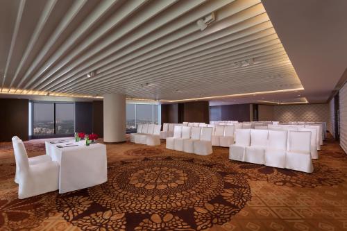 a room with white chairs and tables in a room at Crowne Plaza Dhaka Gulshan by IHG in Dhaka