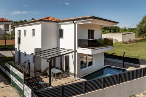 a house with a swimming pool on a roof at Villa Tadini JOY in Babići