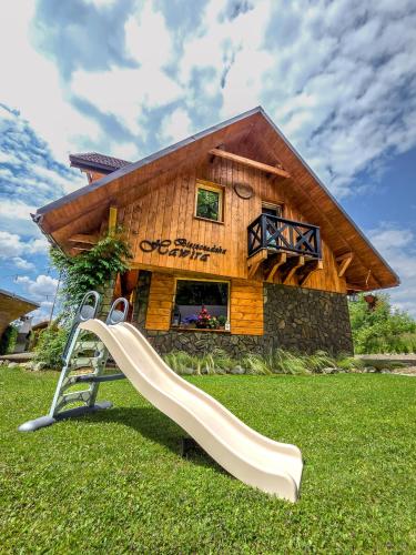 a slide in the grass in front of a house at Bieszczadzka Hawira - Domki w Centrum przy Jeziorze z Widokiem dla Rodzin in Polańczyk