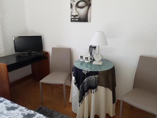 a room with a table with a lamp and a desk at Casa do Cabo de Santa Maria in Sagres