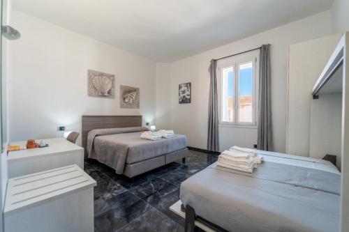 a bedroom with two beds and a sink and a tub at dream house in Olbia