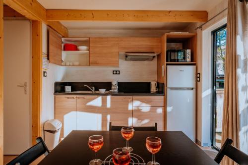 a kitchen with a table with wine glasses on it at Village Vacances de Combelles in Le Monastère