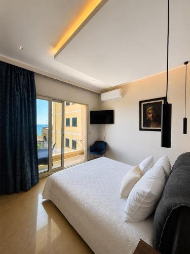 a bedroom with a white bed and a large window at IG - "Villa Don Antonio" Apartments in Giardini Naxos