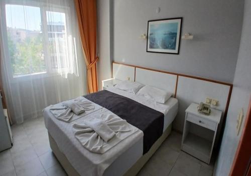 a bedroom with a bed and a window at Golden Moon Apart Hotel in Kuşadası
