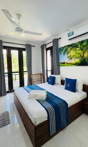 a bedroom with a large bed with blue pillows at Breedon Residence Hotel in Anuradhapura