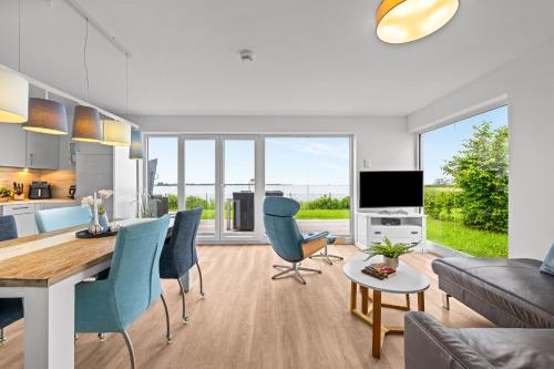 a kitchen and living room with a table and chairs at Ferienwohnung WeitBlick Olpenitz in Olpenitz