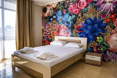 a bedroom with a bed with a floral wall at Arapya Resort in Arapya