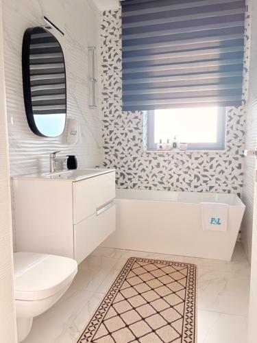 a bathroom with a toilet and a sink and a mirror at F&Lrelax-Apartamente de închiriat aproape de plajă in Mamaia Sat/Năvodari