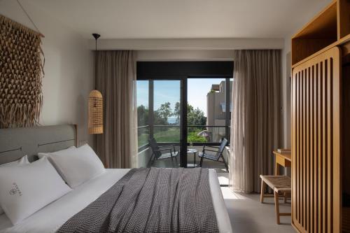 a bedroom with a bed and a view of a balcony at Villas THALLO in Paradisos