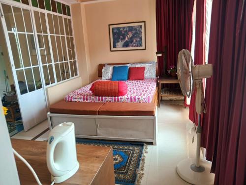 a bedroom with a bed with red and blue pillows at SAI´S GRACE in Kalimpong