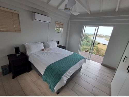 a bedroom with a bed and a large window at Beautiful Lagoon House in Blythedale
