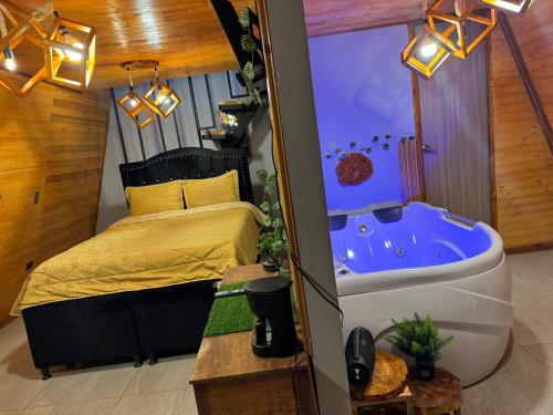 a bedroom with a bed and a bath tub at Lago de Tota GALAMPLAY lodge in Tota