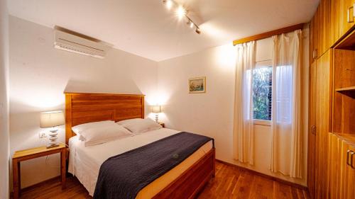 a bedroom with a large bed and a window at Waterfront Villa Dora by Villas Guide in Smokvica