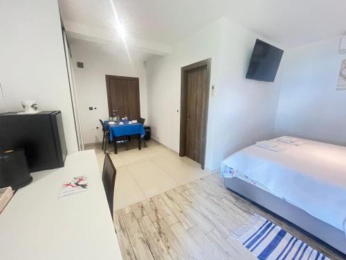 a bedroom with a bed and a table and a television at Room Lina in Lovran