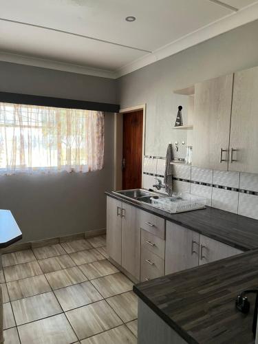 a kitchen with a sink and a counter top at Gemstone Guest House in Klerksdorp