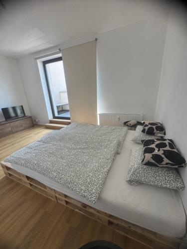 a large bed with pillows on it in a room at StayCentralcz- Studio in Opava