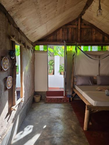 a small room with a bed and a window at Backyard Eco Bungalows Moshi in Moshi