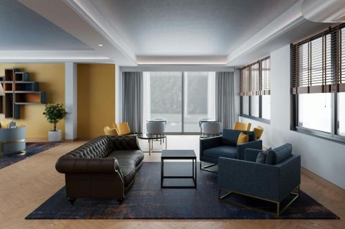 a living room with a couch and two chairs at Four Points Flex by Sheraton Parma in Parma