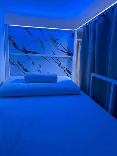 a blue bedroom with a bed with blue lighting at Best Inn Hostel and Café Patong Beach in Patong Beach