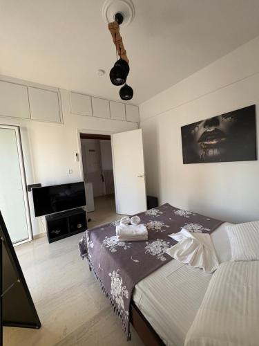 a bedroom with a bed and a flat screen tv at Sisyphys Kingdom in Korinthos