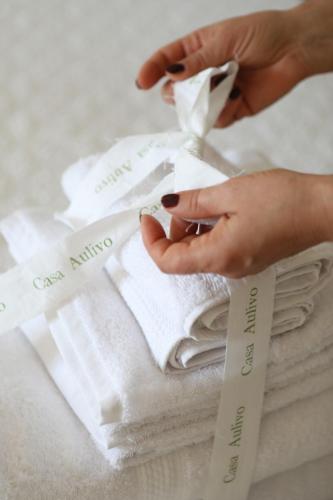 a woman is putting towels on a stack of towels at Casa Aulivo, dimora storica con vista in Caiazzo