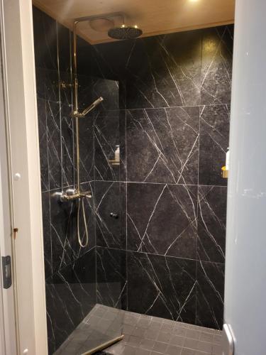 a bathroom with a black tiled shower at Villa Korsman in Hanko