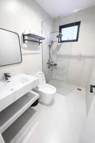 a white bathroom with a sink and a toilet at The SunHill Dalat in Ấp Ða Lợi