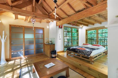 a bedroom with a bed in a room with wooden floors at La Cabane Zen in Angoisse