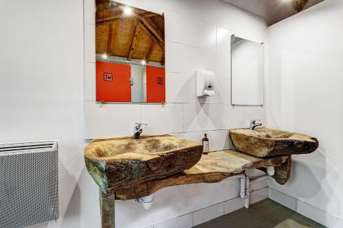 a bathroom with two sinks and a mirror at La Cabane Zen in Angoisse
