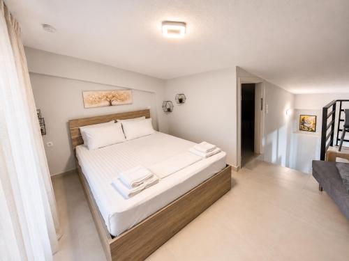 a bedroom with a large bed with white sheets at Crystal 2 Apartment Ofrinio in Ofrínion