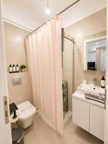 a bathroom with a shower curtain and a toilet at Crystal 2 Apartment Ofrinio in Ofrínion