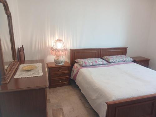 a bedroom with a bed and a dresser and a lamp at appartamento 4 piano in Chioggia